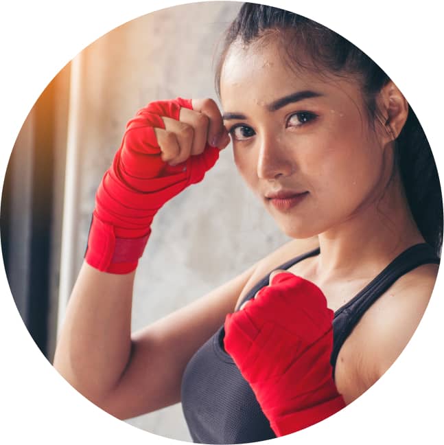 真剣な表情でファイトポーズをとる女性トレーニー