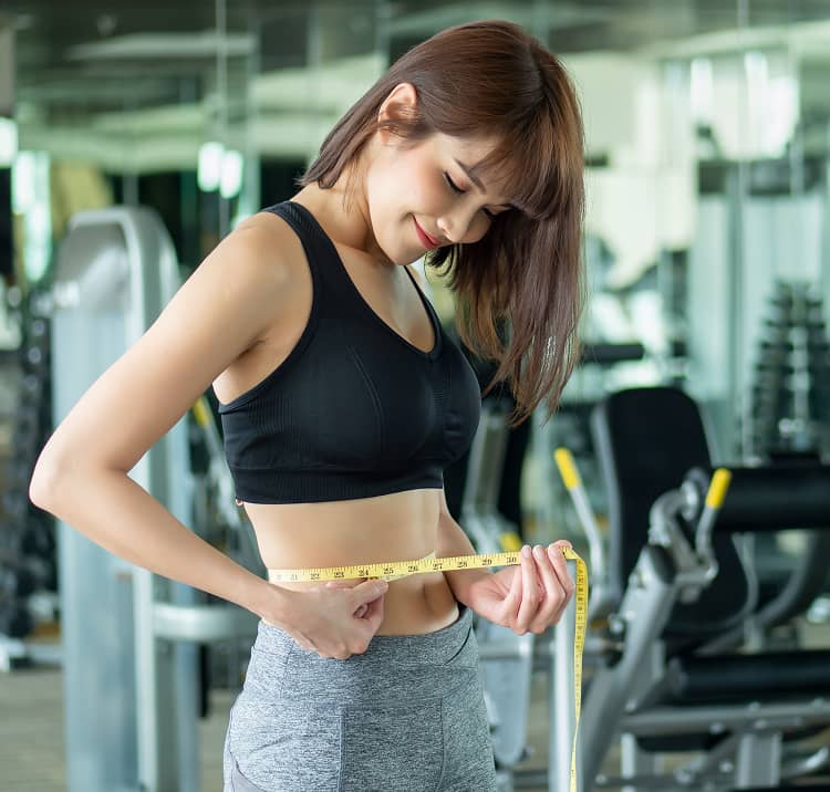 トレーニング後にウエストラインを確認するフィットネス女性