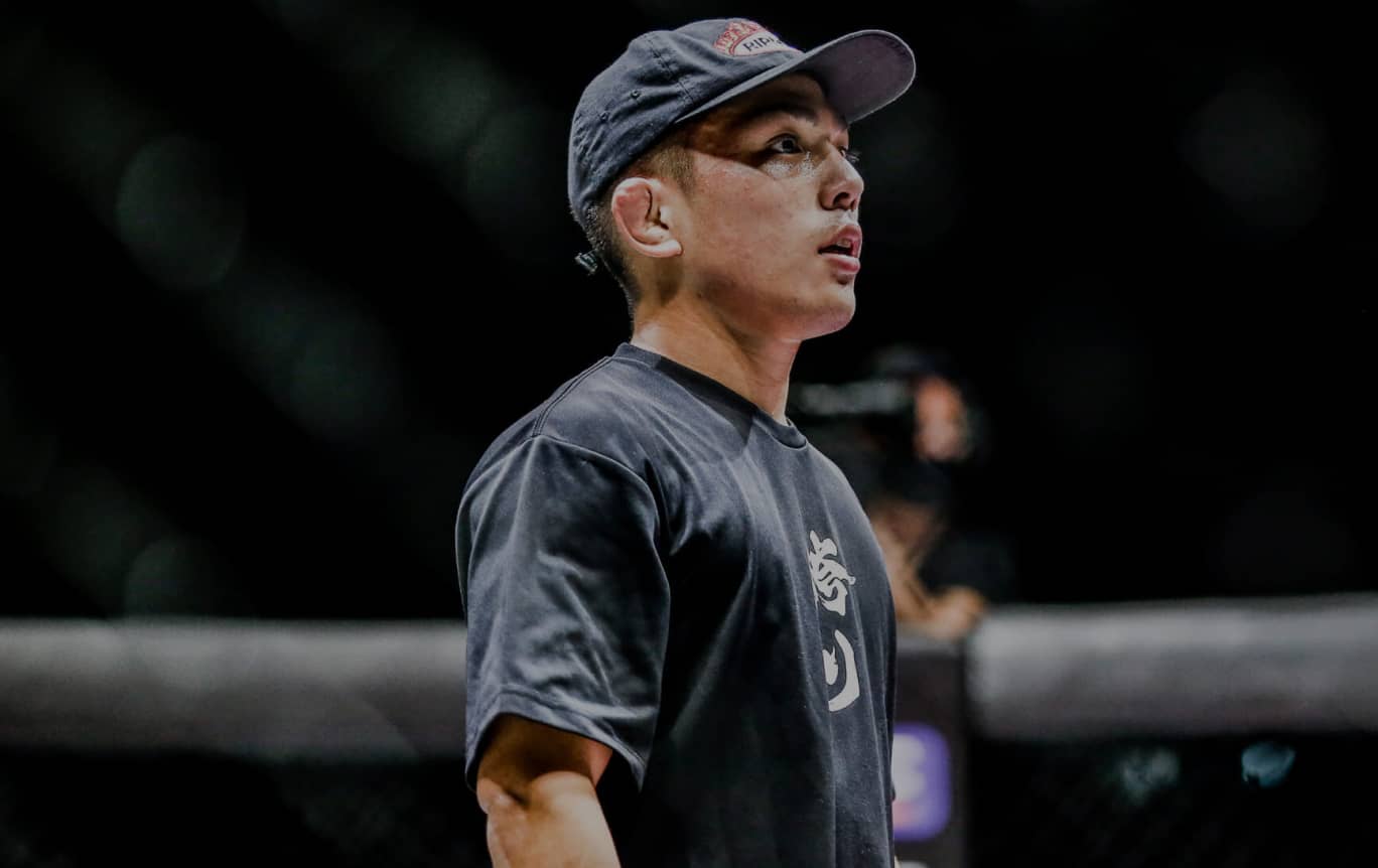 黒いキャップとシャツを着た男性のクローズアップ。スポーツイベント中に集中している様子。
